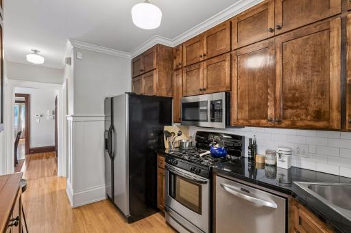 The kitchen has been updated with prairie style dark stained cabinets, black countertops & stainless appliances.