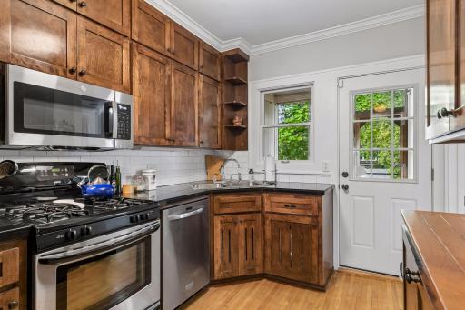 The kitchen has been updated with prairie style dark stained cabinets, black countertops & stainless appliances.
