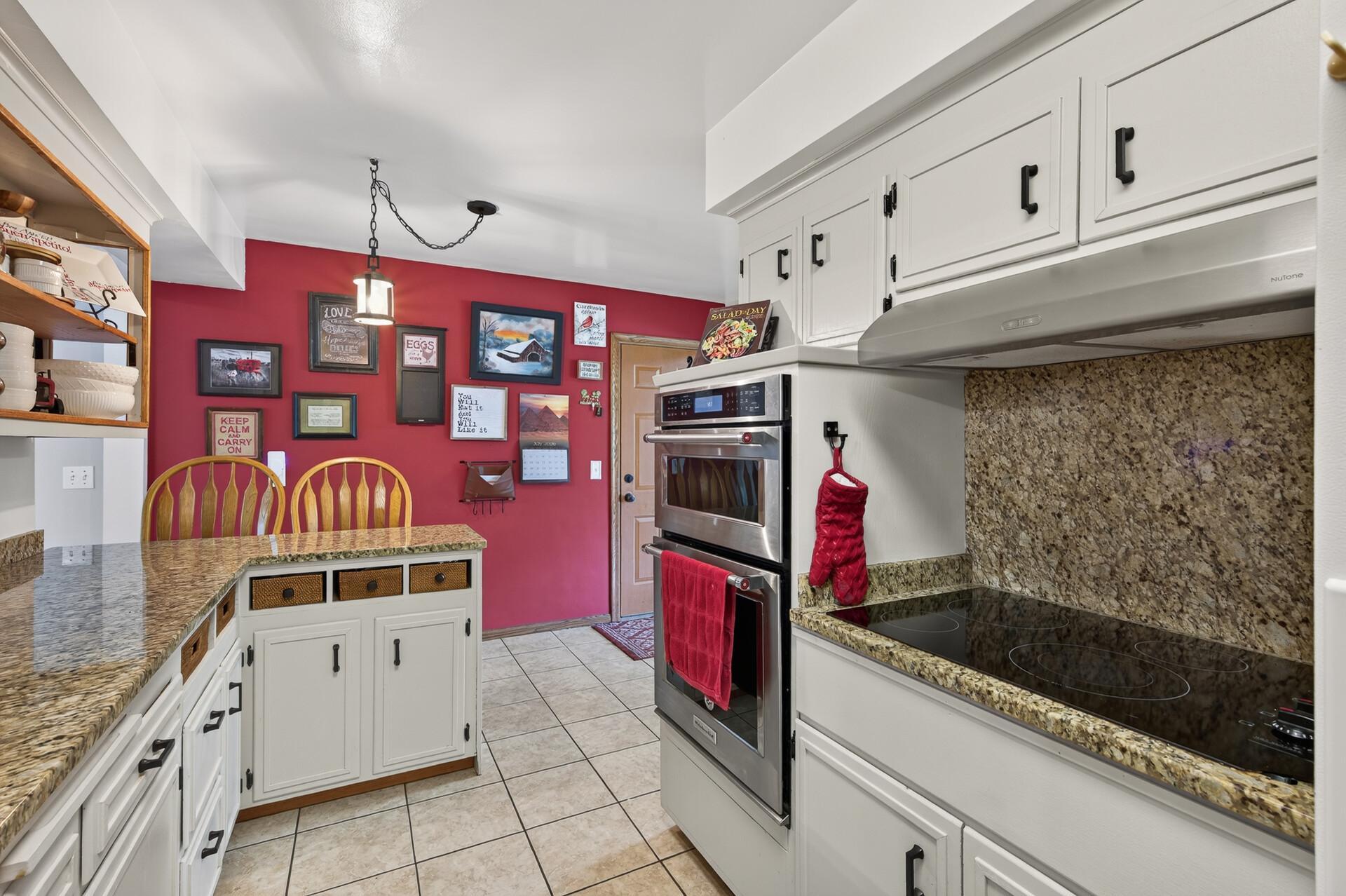 Main level: kitchen with granite counters, stainless appliances, and a new cooktop