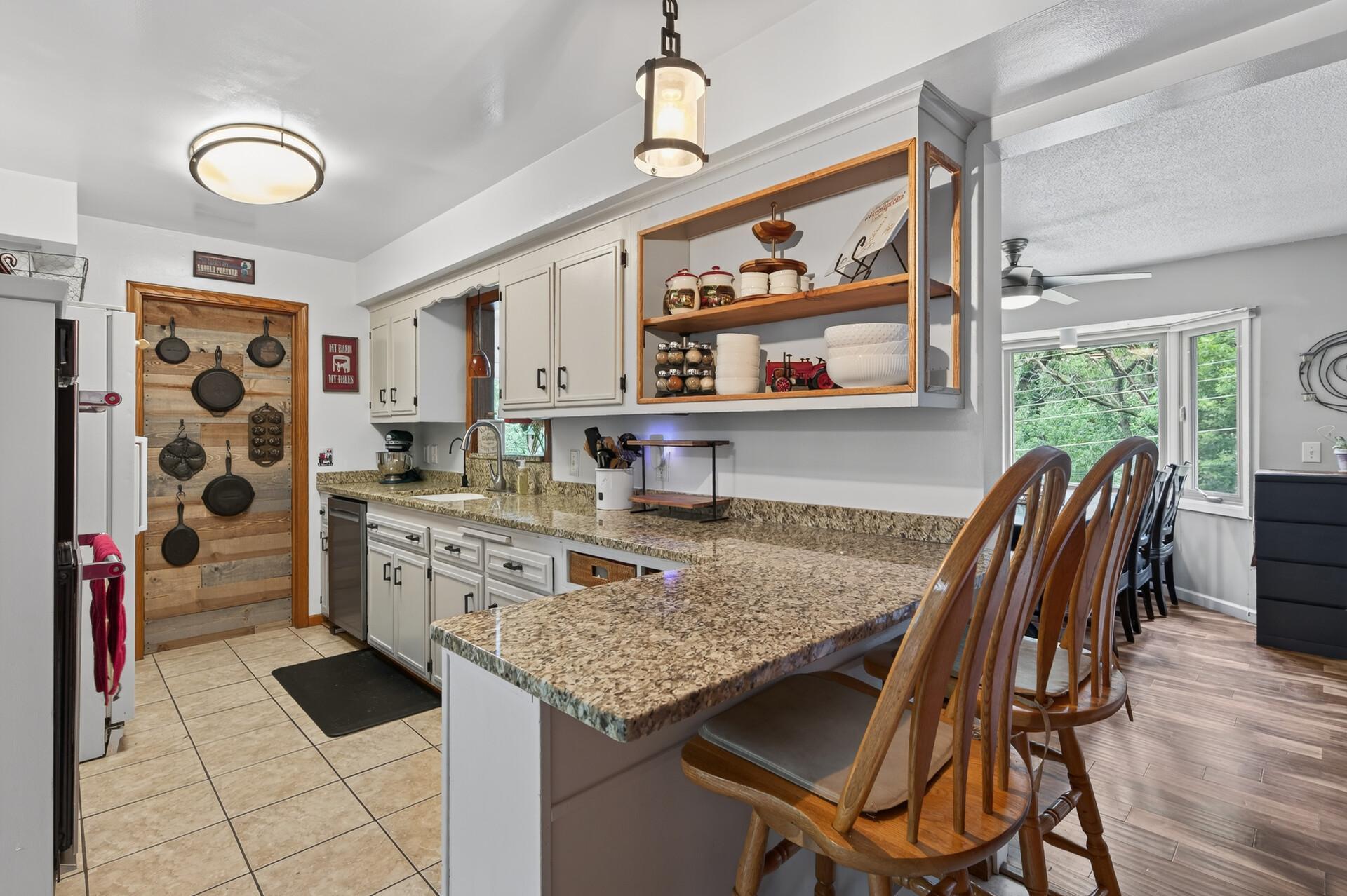Main level: kitchen with granite counters, stainless appliances, and a new cooktop