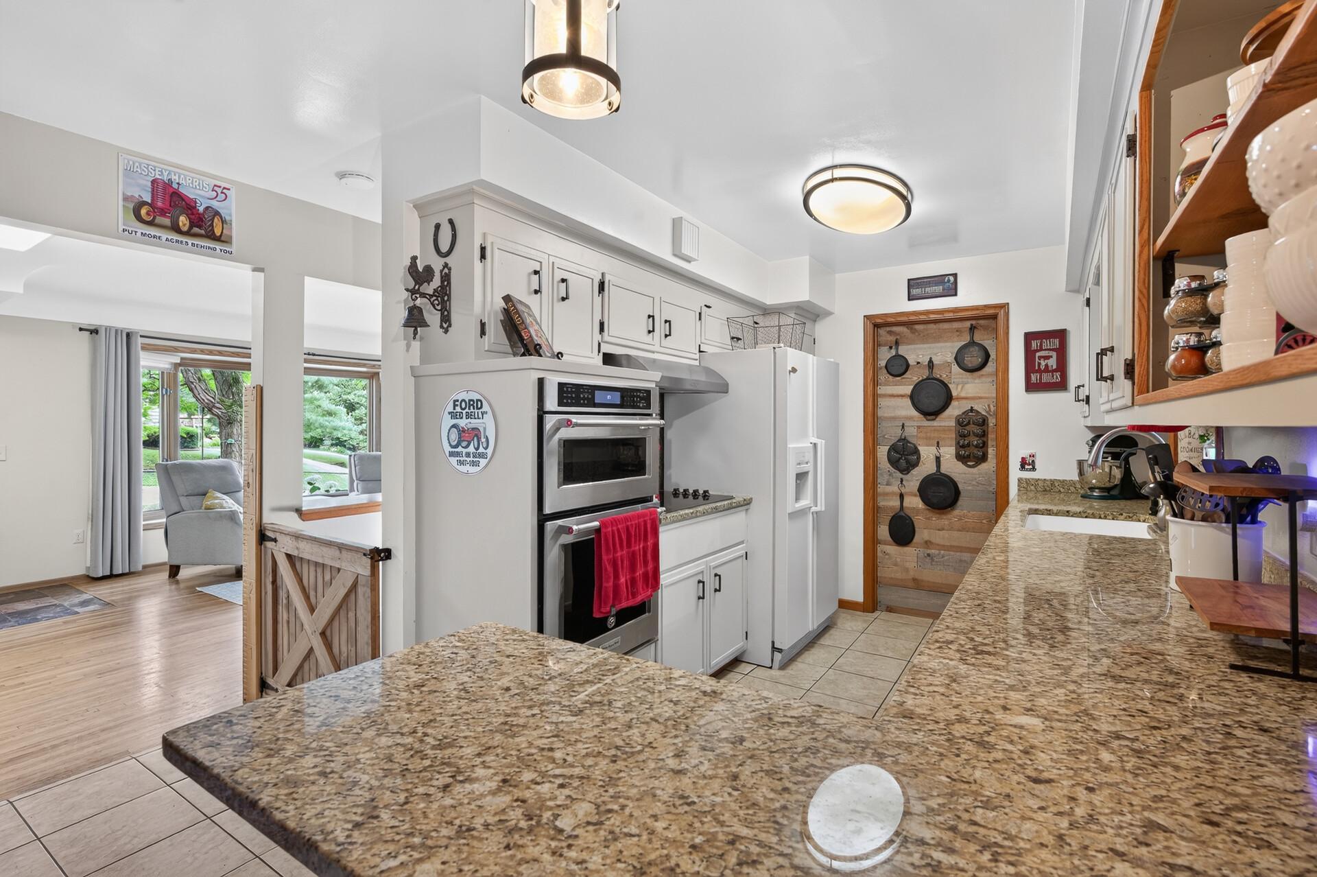 Main level: kitchen with granite counters, stainless appliances, and a new cooktop