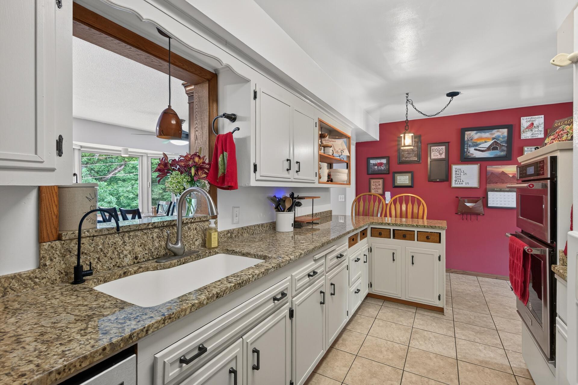 Main level: kitchen with granite counters, stainless appliances, and a new cooktop