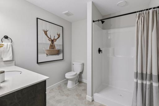 A stylish 3/4 bathroom serves the lower-level bedrooms and family room.