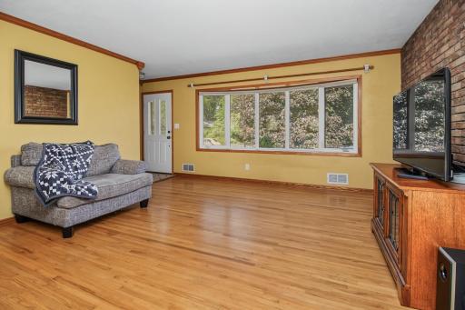 Large living room with bay windows and hardwood floors.