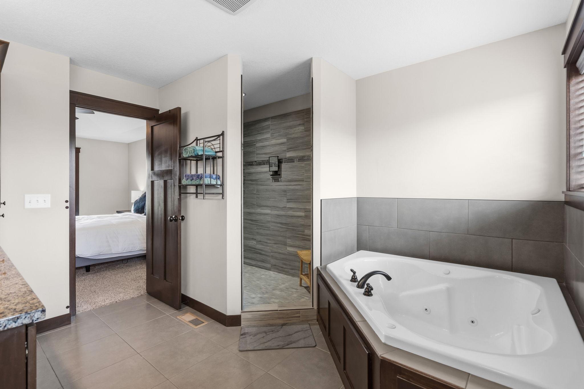 Spa-inspired primary bath featuring a soaking tub and walk-in tiled shower.