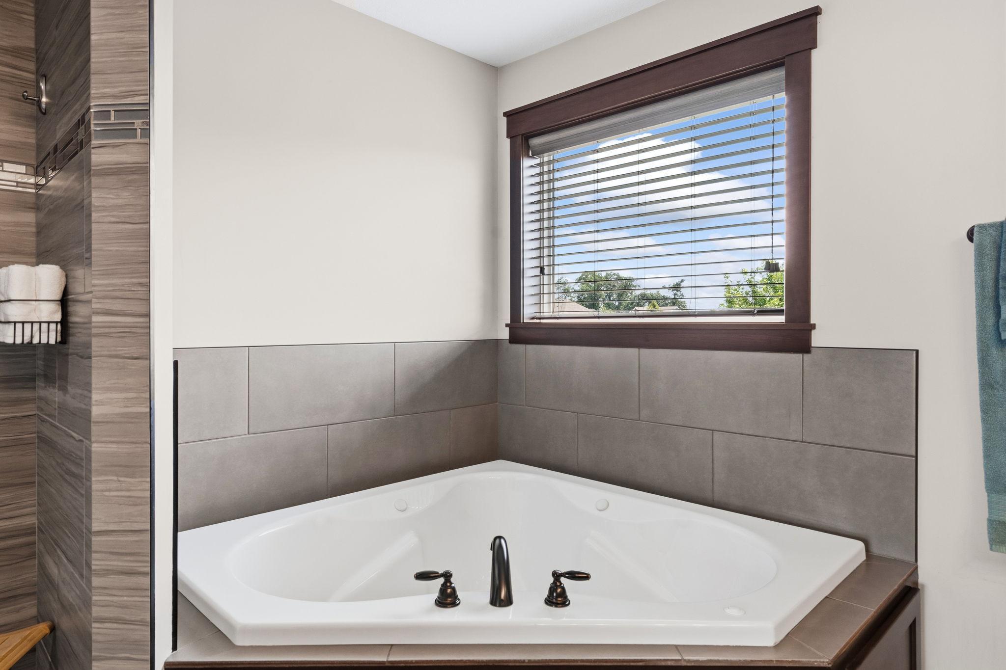 Relax in the luxurious jetted soaking tub with natural light from the large window.
