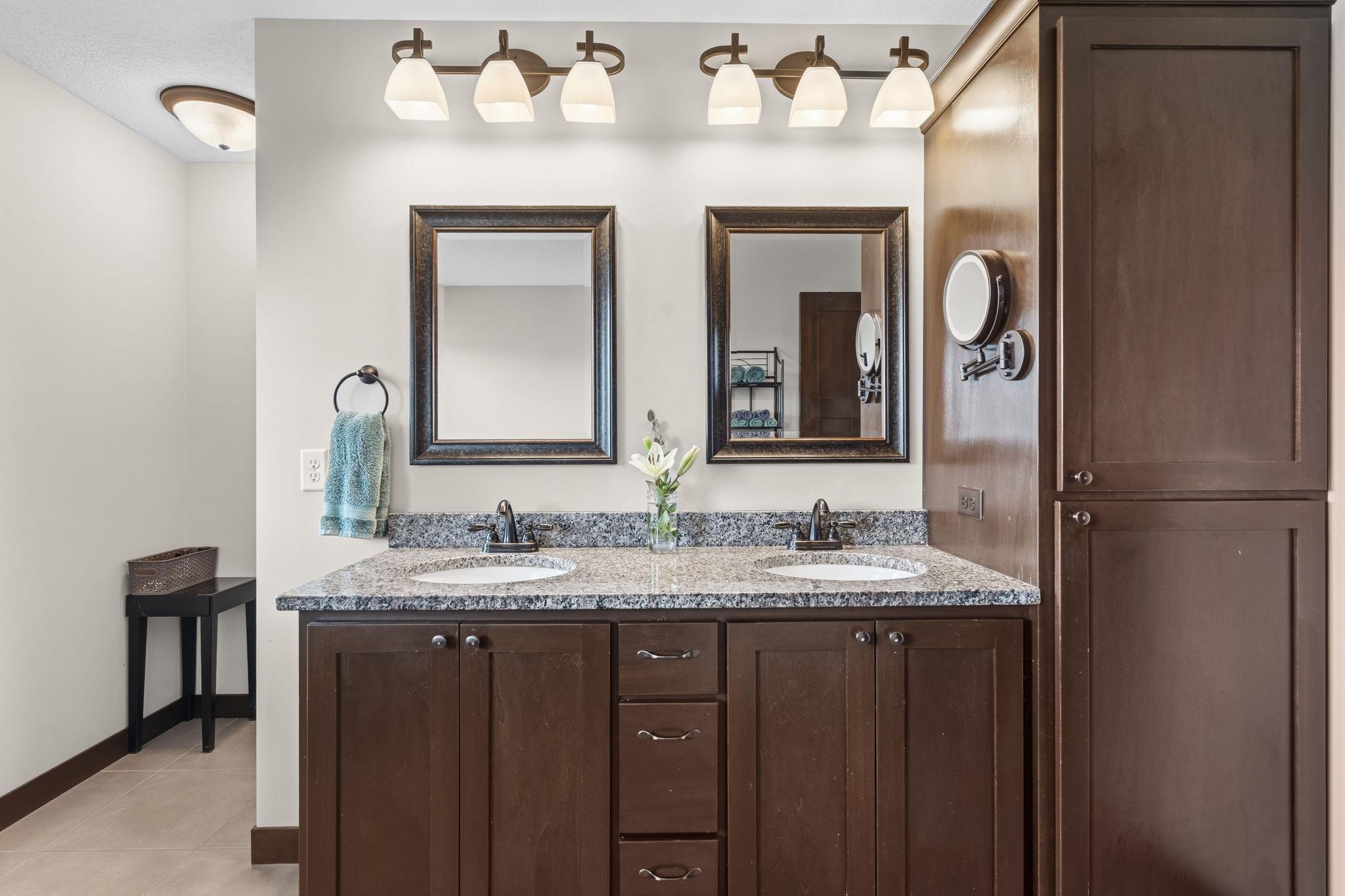 Dual-sink vanity with granite countertops and generous cabinet storage.