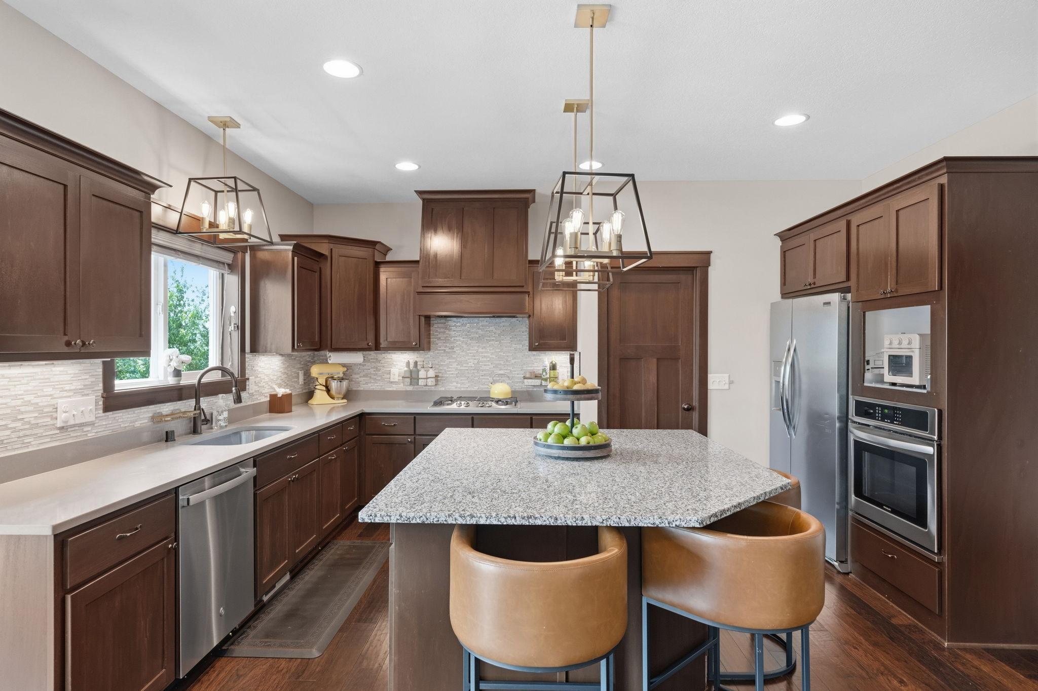 Beautifully appointed kitchen with oversized center island, granite countertops, and abundant cabinetry.