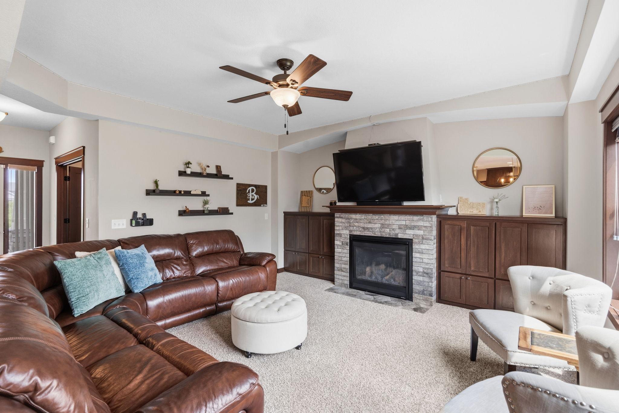 Spacious great room featuring a cozy gas fireplace and custom built-in cabinetry.
