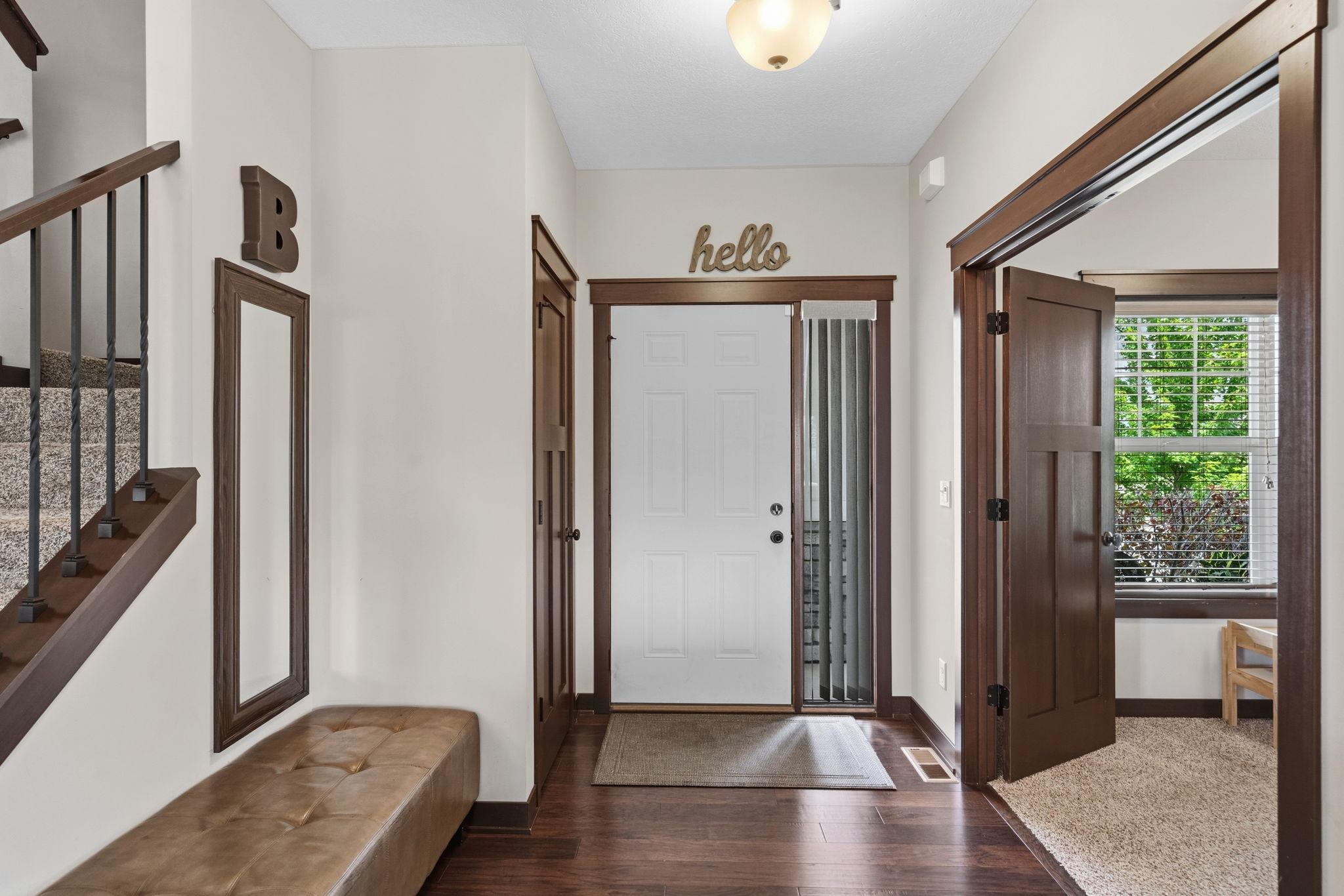 Spacious foyer with hardwood floors and convenient coat closet.