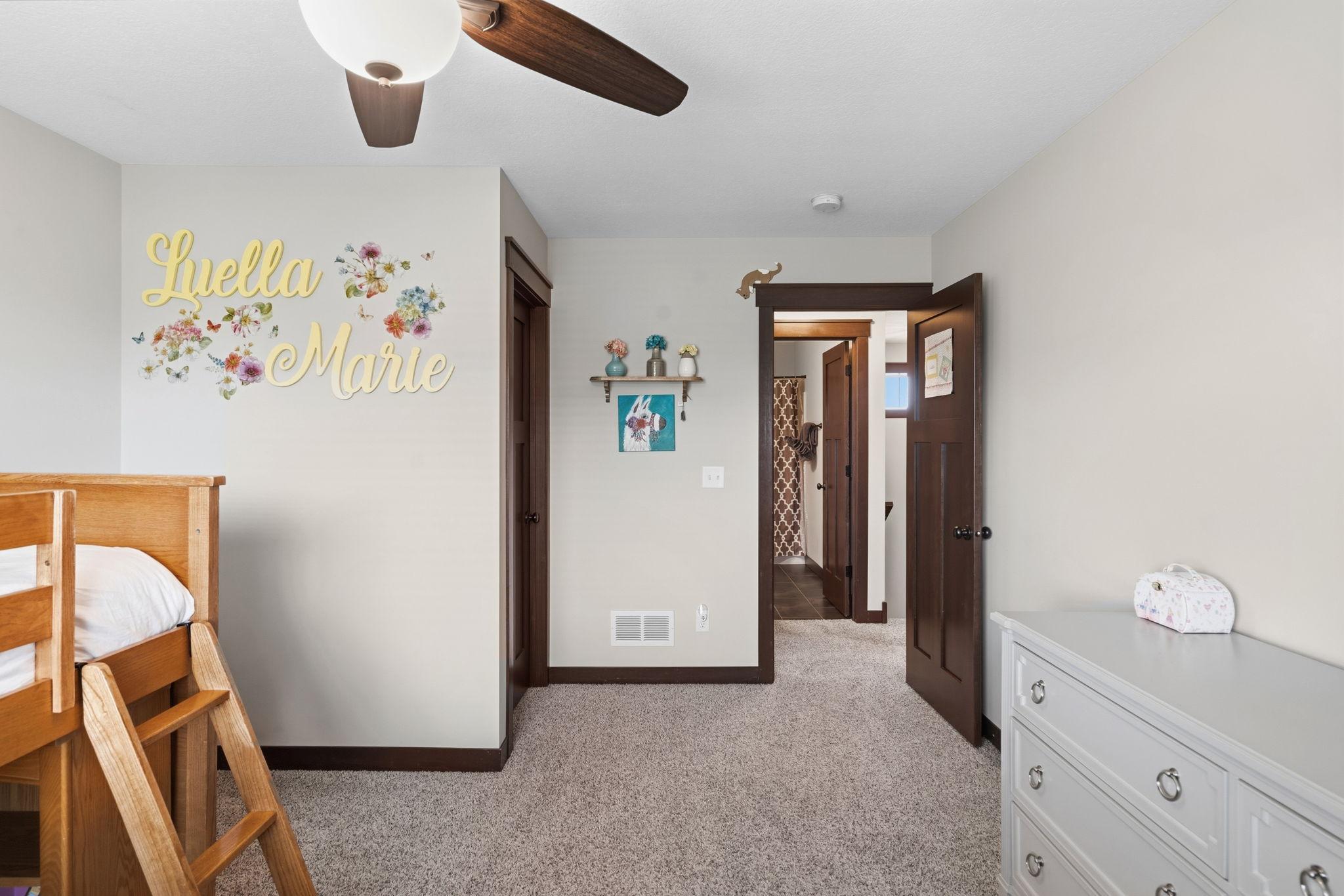 Bright secondary bedroom with large window and walk-in closet.