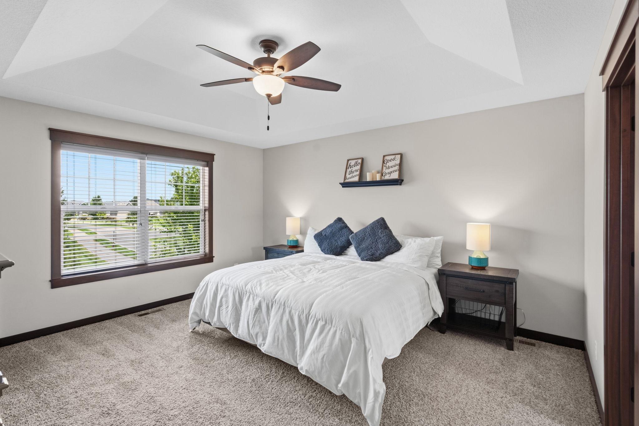 Spacious primary suite with tray ceiling and large picture window.