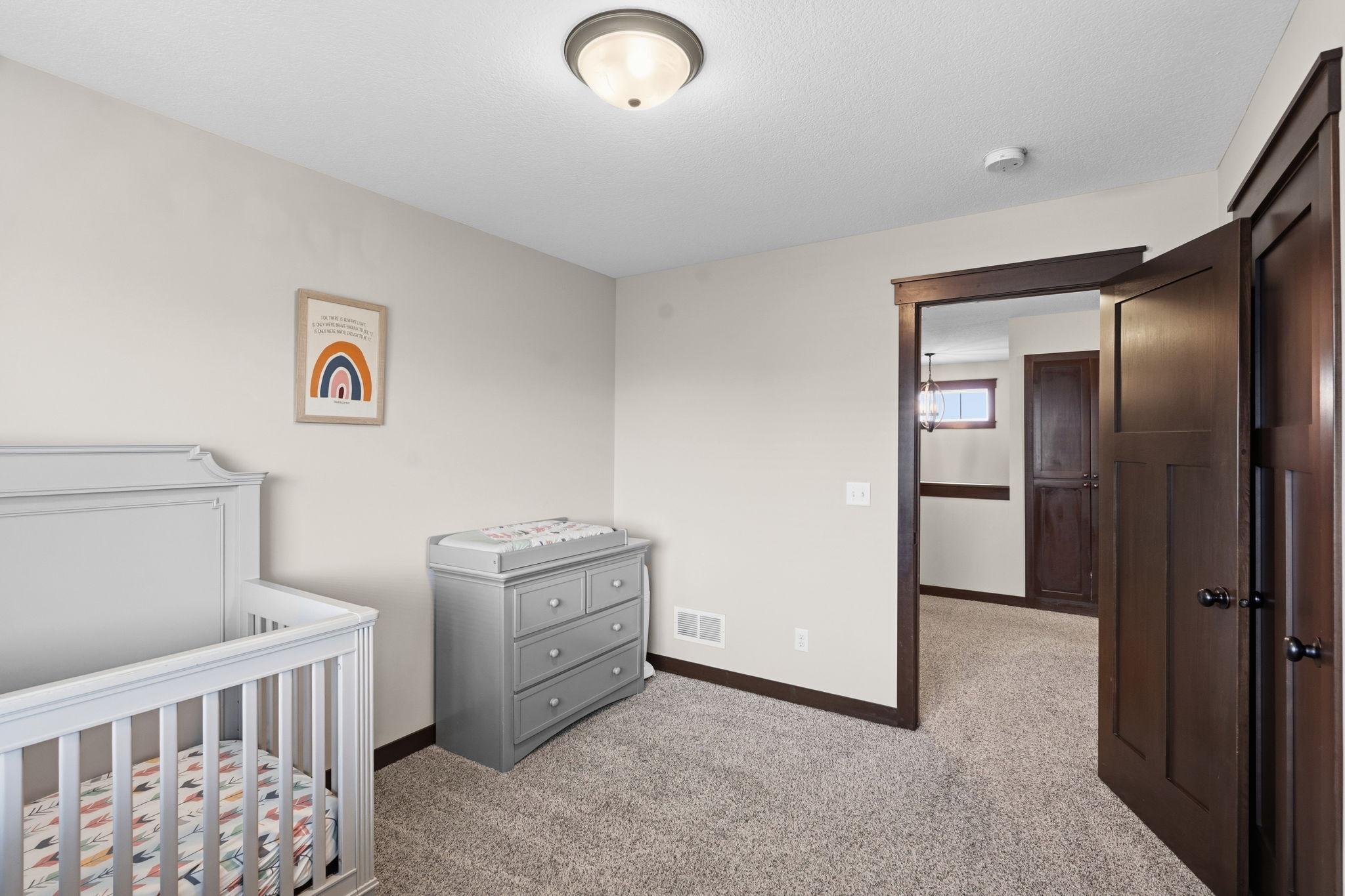 Spacious secondary bedroom with neutral finishes and generous closet space.
