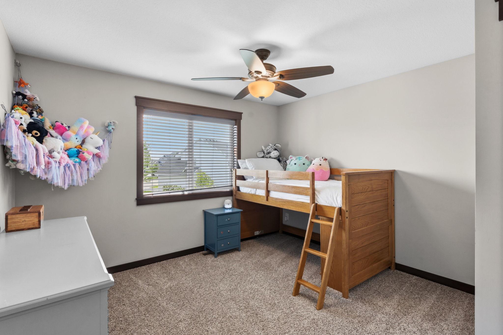 Spacious secondary bedroom with ceiling fan, large window, and generous natural light.