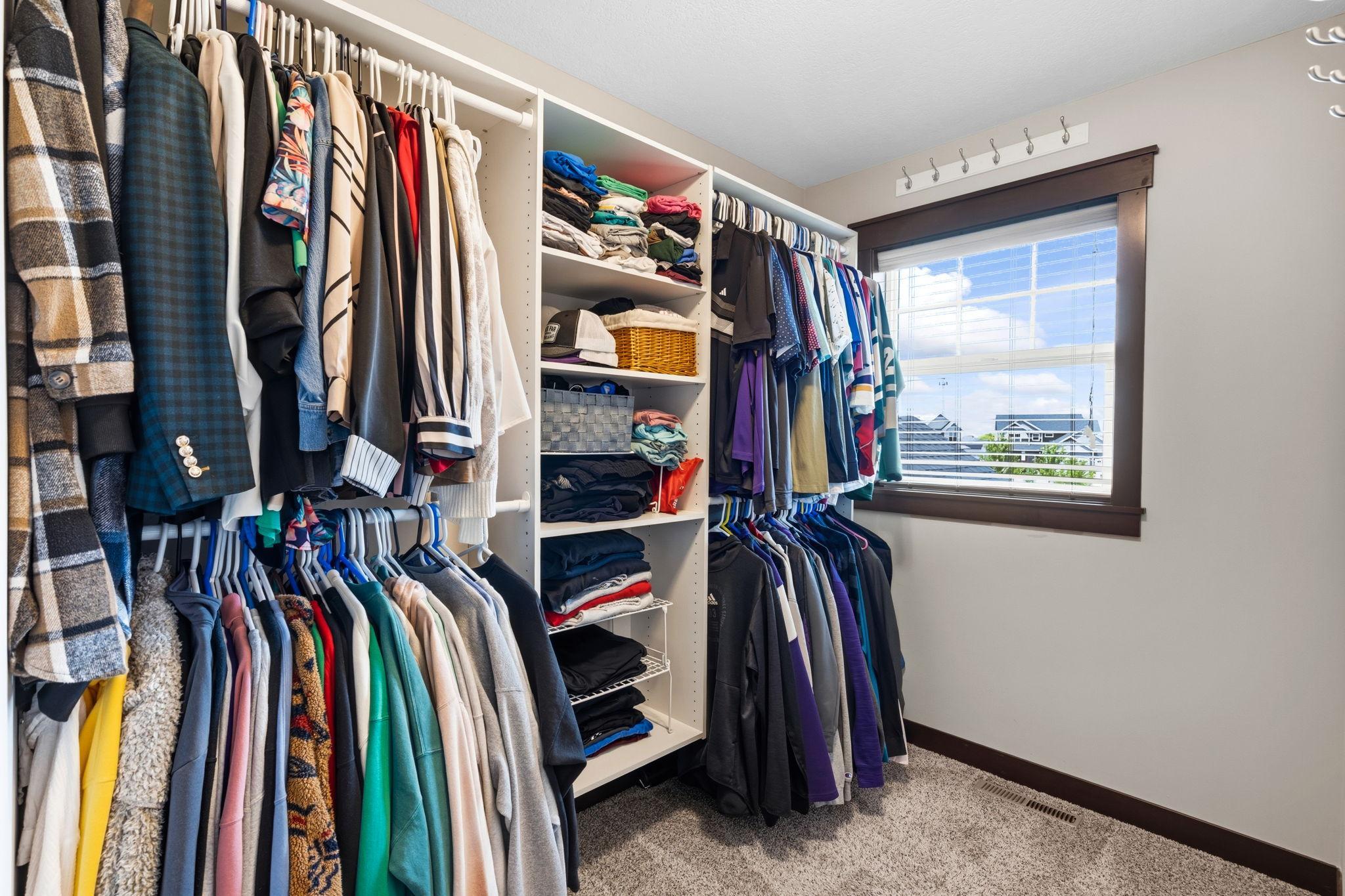 Large walk-in closet with custom organization system and natural light.