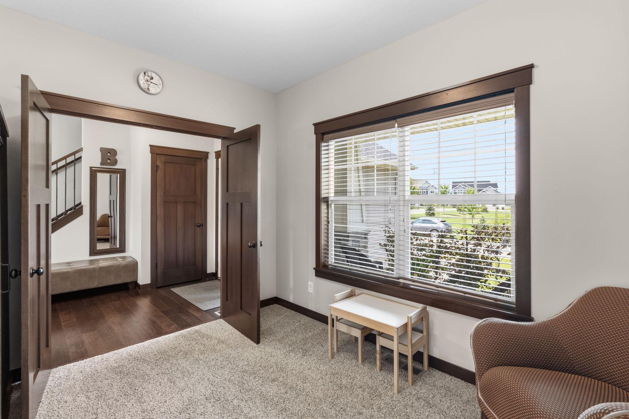 Bright front flex room with large picture window, ideal as an office or sitting room.
