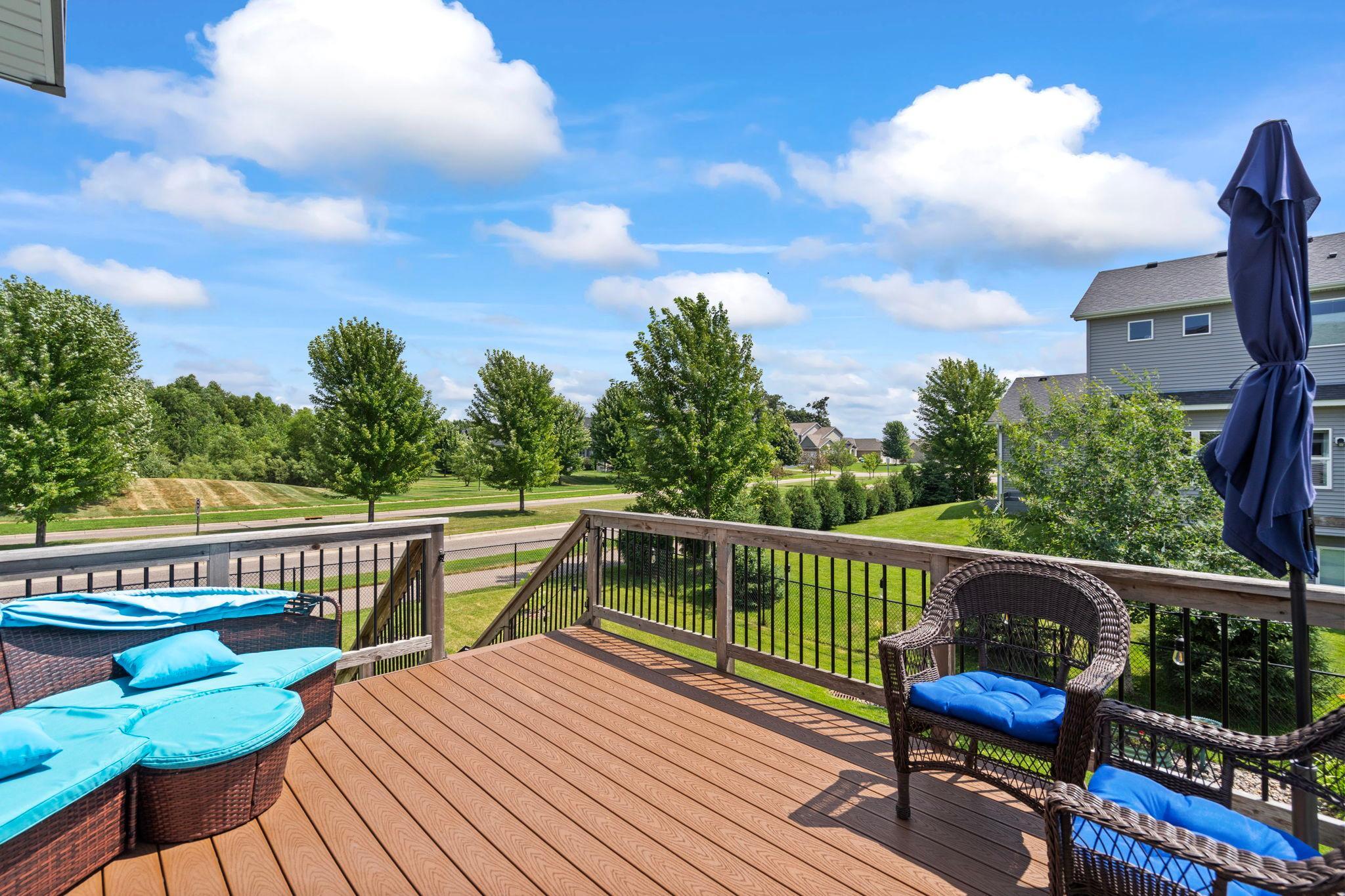 Deck featuring maintenance-free deck boards with views of the backyard and open green space.