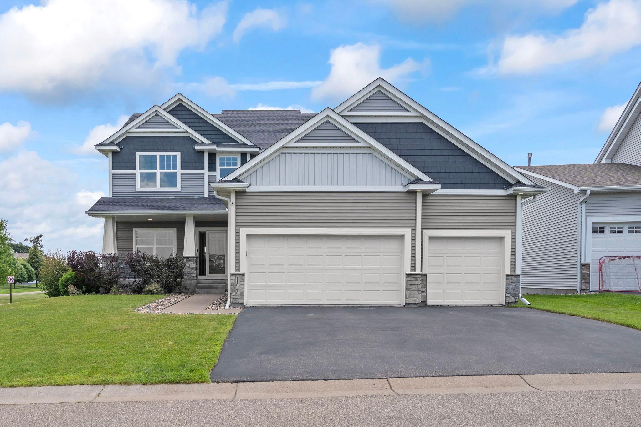 Attractive two-story home showcasing exceptional curb appeal, a three-car garage, and beautifully maintained landscaping.