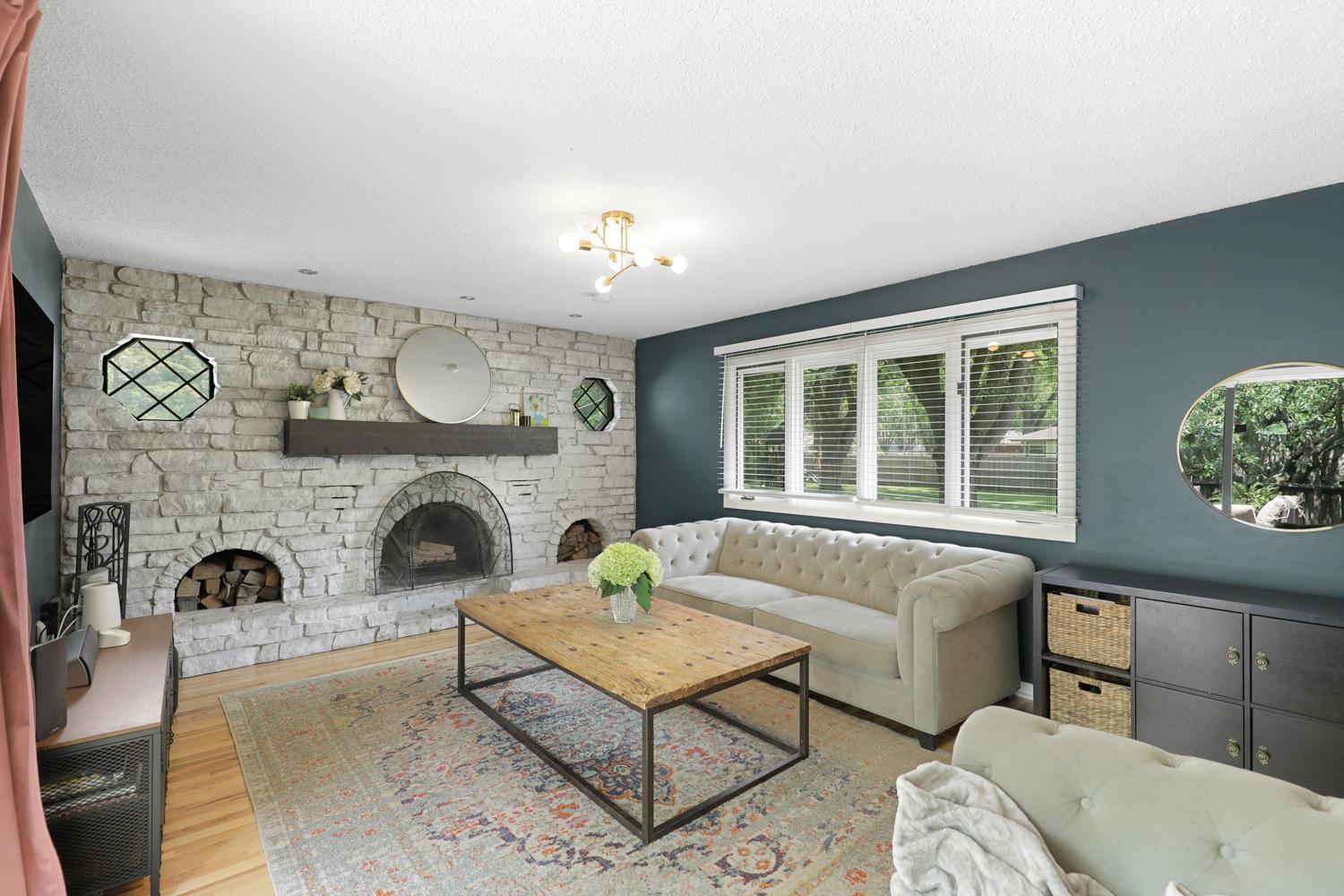 The open concept flows into the living room featuring a wood burning fireplace