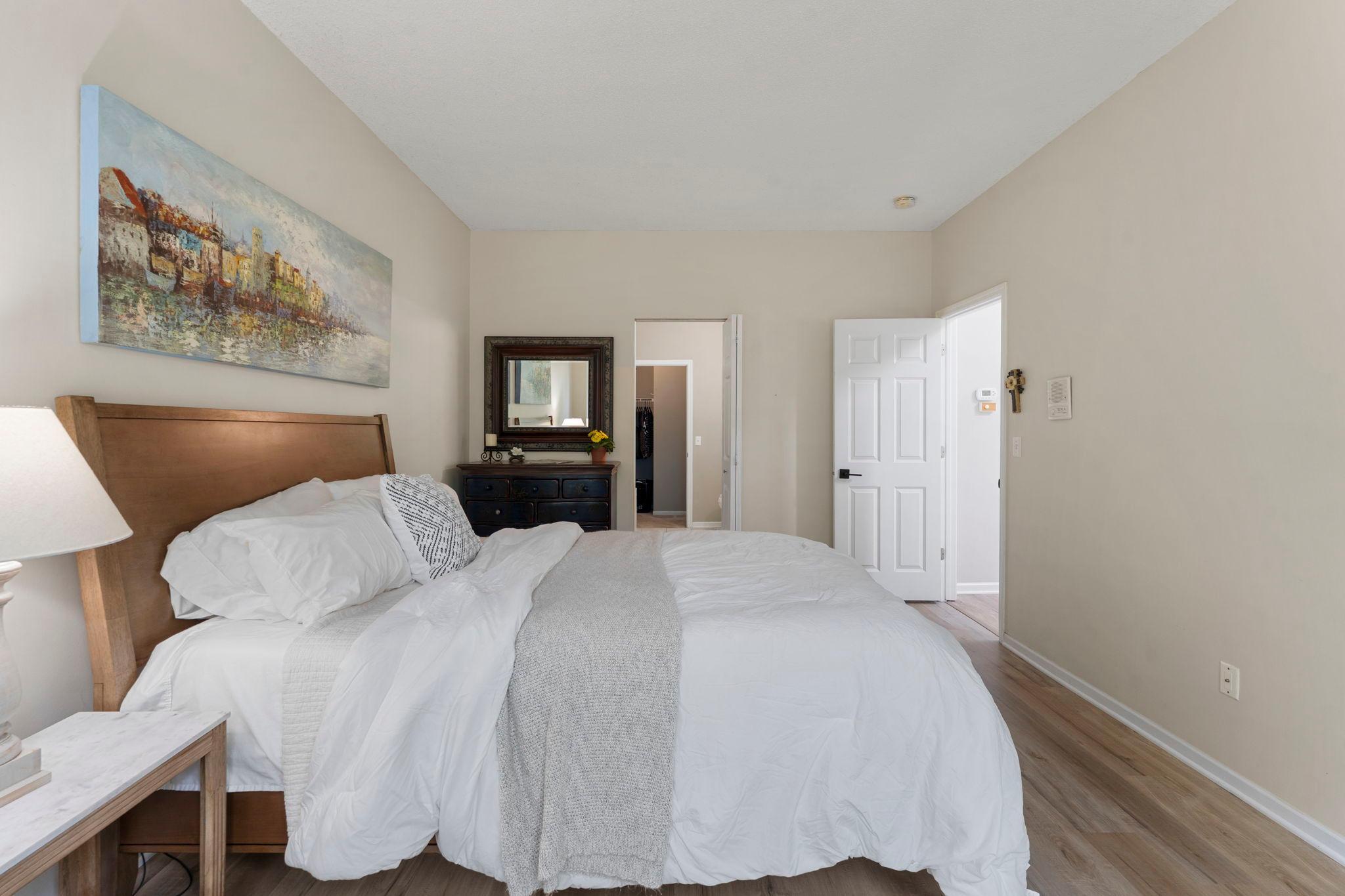 Another angle of the inviting primary bedroom highlighting the entrance to the private full bathroom.