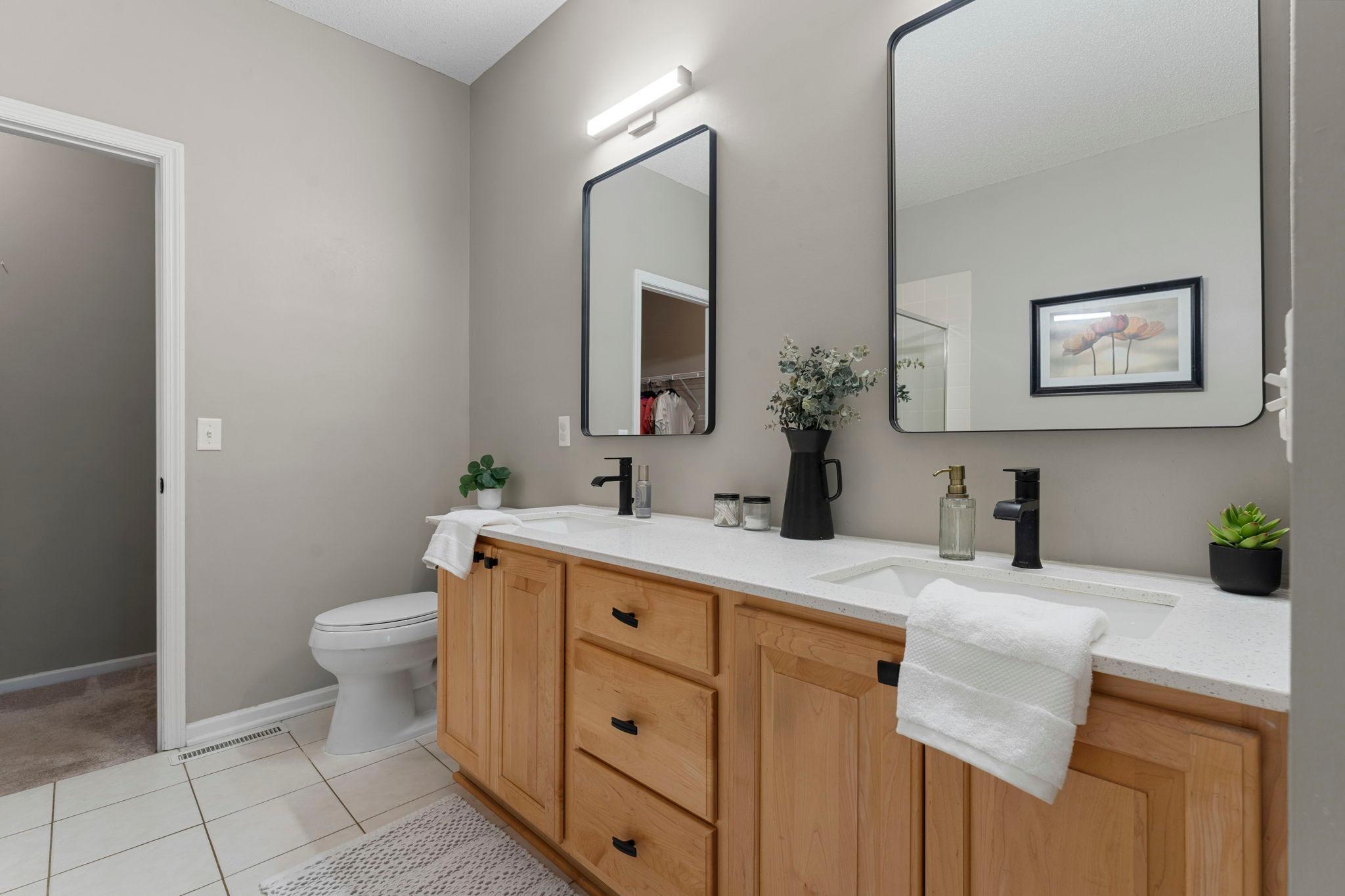 The private bathroom features a separate jetted tub and shower, newly installed dual sink vanity with quartz countertops, updated lighting fixtures, and a generous 9x5 walk-in closet.