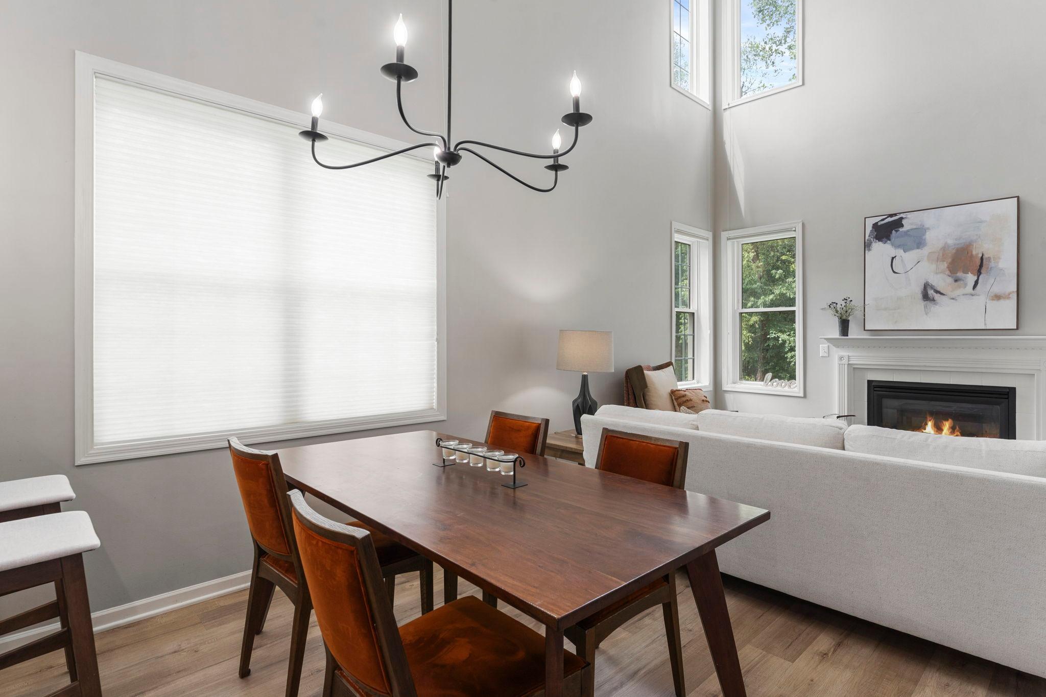 Nearby, the dining space features impressive 18-foot ceilings and a classic hanging chandelier, creating the perfect setting for sharing meals and entertaining.