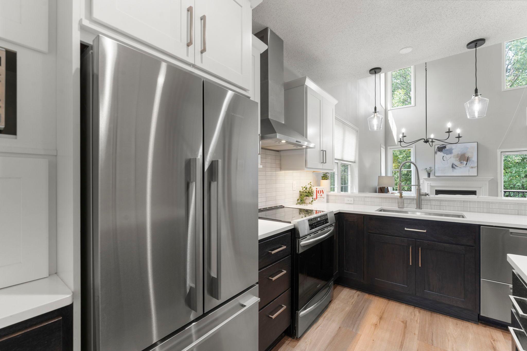 Beautifully remodeled kitchen with custom cabinetry, Cambria countertops, a spacious island with breakfast bar seating, and premium stainless steel appliances.