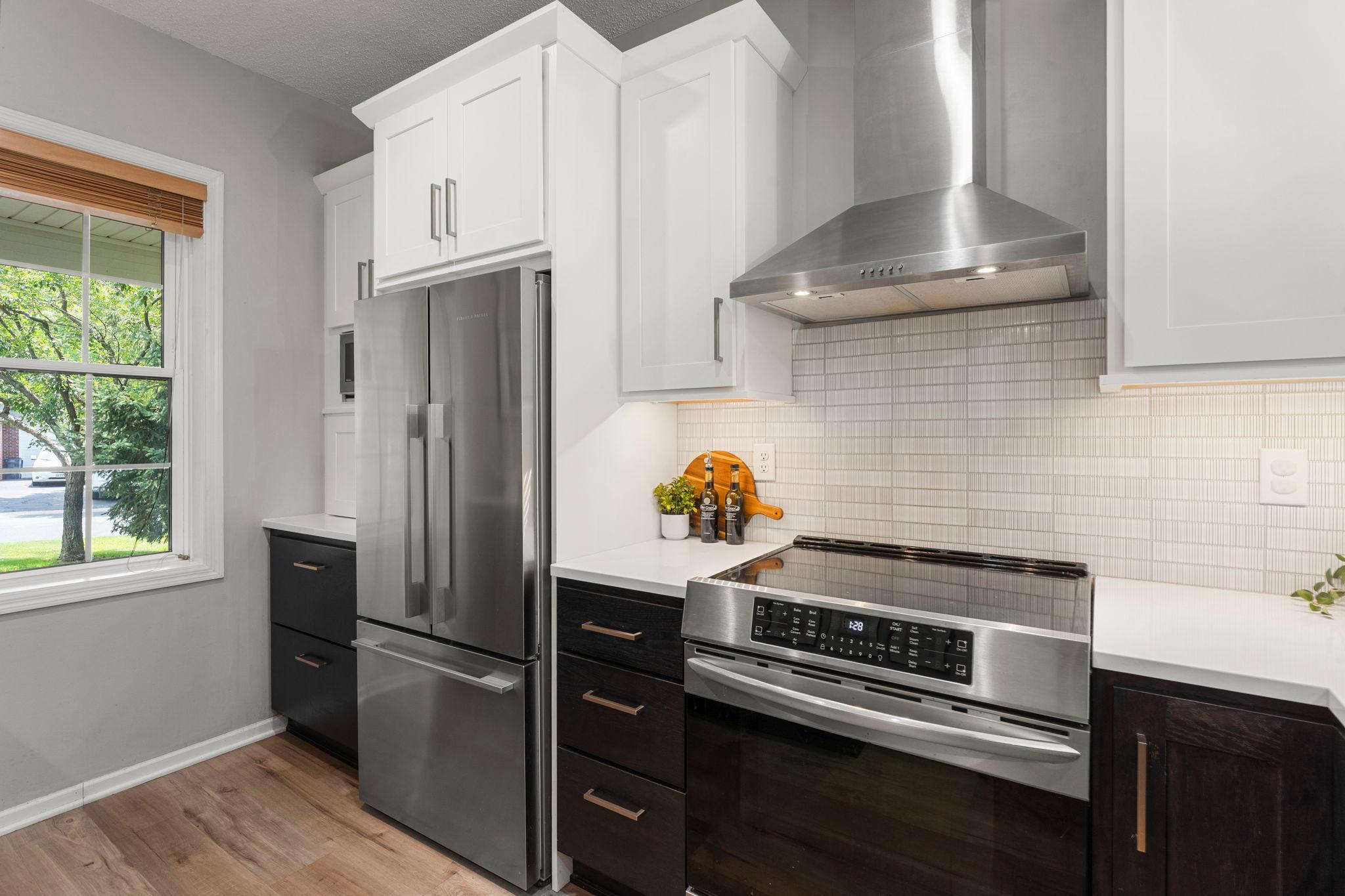 Chef-inspired kitchen featuring a Fisher & Paykel refrigerator, two-drawer dishwasher, induction range with oven, soft-close cabinetry, and stunning Cambria countertops.