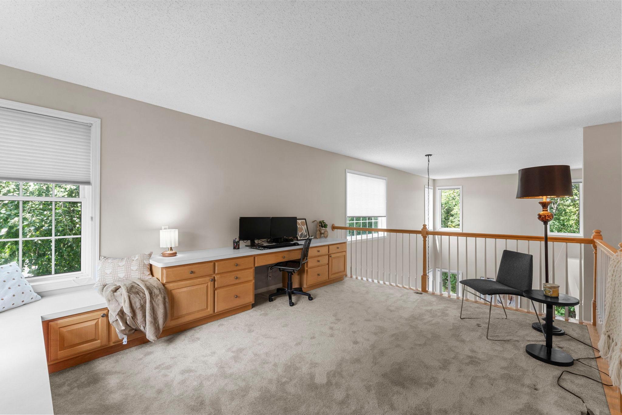 The upper level offers a spacious loft area overlooking the living room and dining space below.