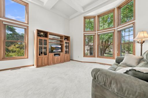 The living room has coffered ceilings, new carpet, and floor to ceiling windows.