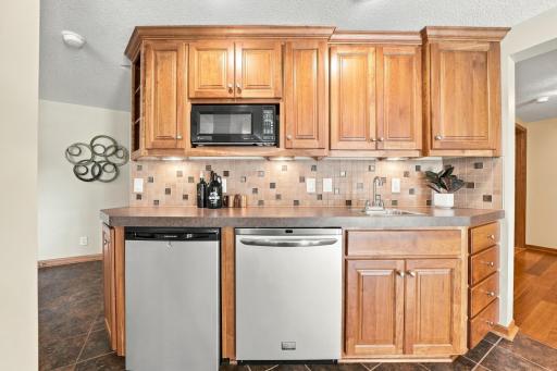 The wetbar features a dishwasher, mini frig, microwave, and sink.