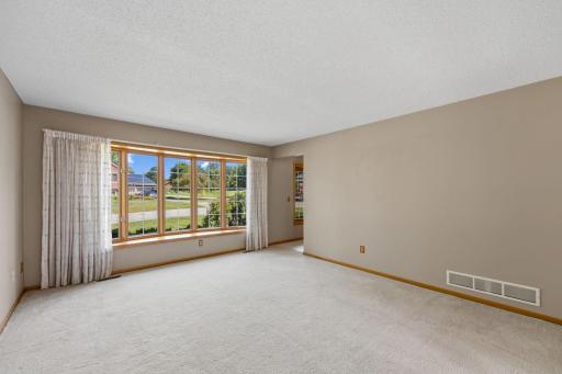 Sunlight pours through the bow window, creating a bright and inviting first impression.