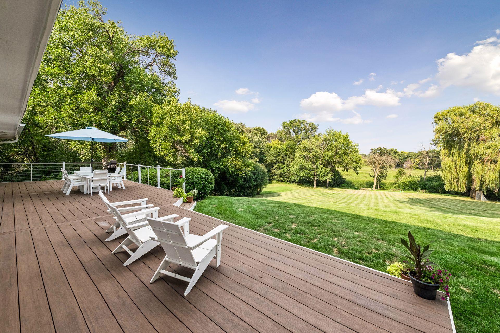 Outdoor living is equally impressive, with a wraparound deck overlooking lush landscaping and peaceful natural surroundings.