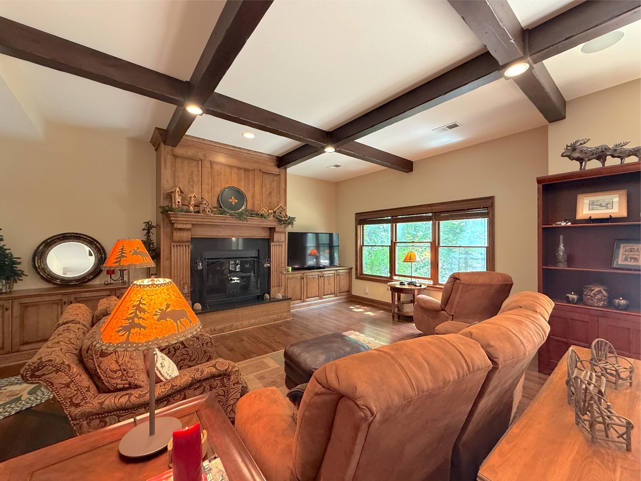 Perfect for entertaining, this spacious basement retreat offers rich wood finishes, a cozy fireplace, and seamless indoor-outdoor living.
