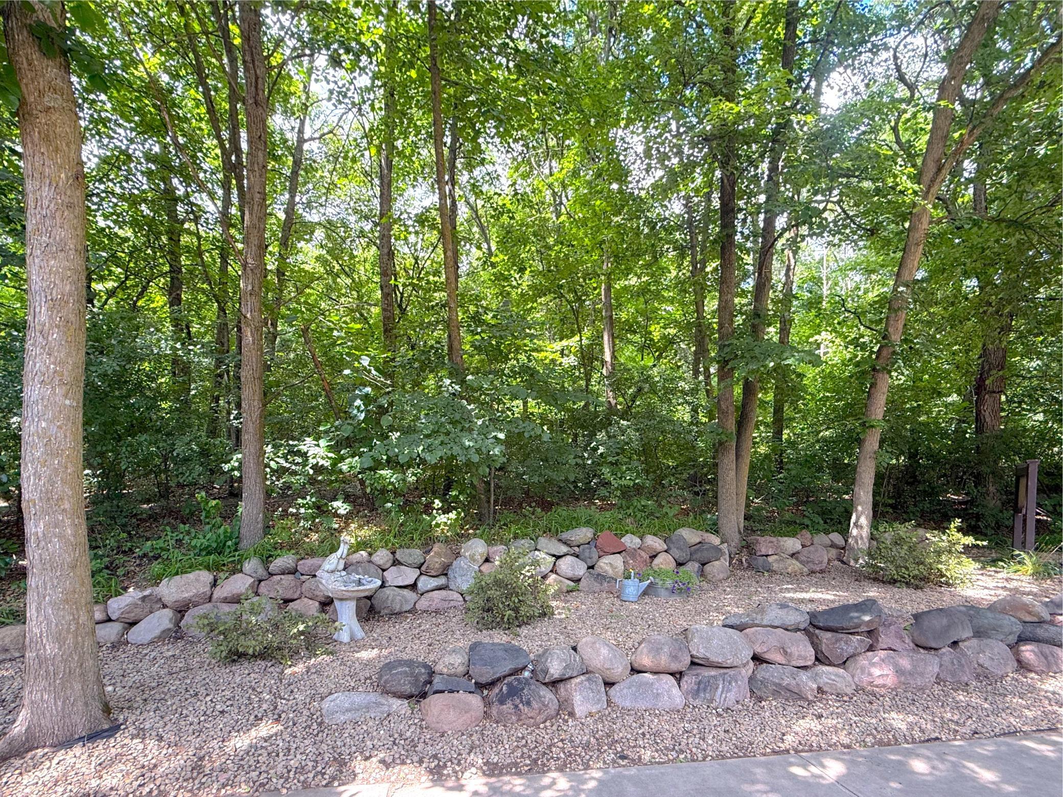 Nestled among towering trees, this beautifully landscaped area enhances the property's tranquil atmosphere and connection to nature.