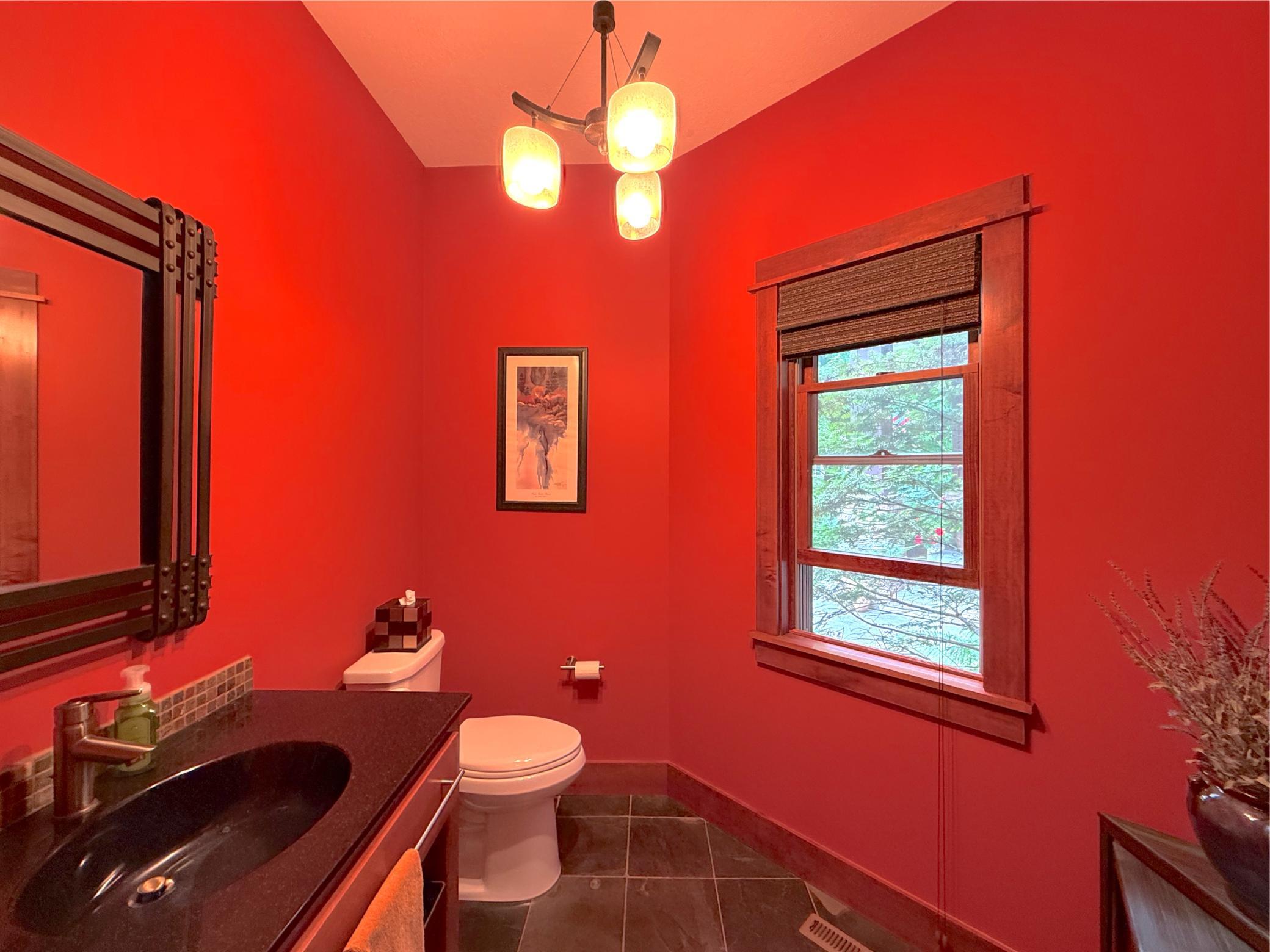 This stylish powder room features bold designer finishes, elegant lighting, and rich wood accents that make a lasting impression.