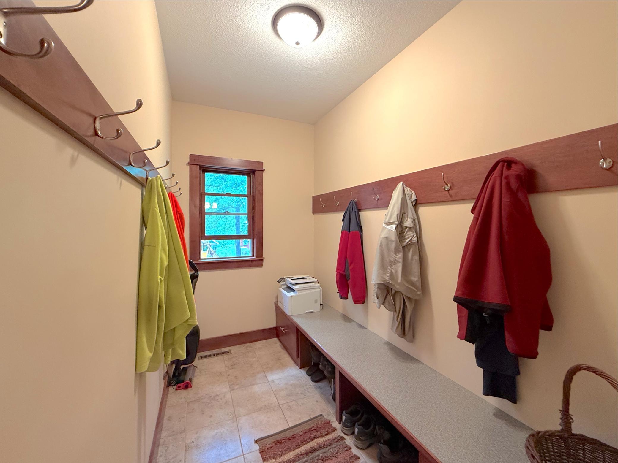 The spacious mudroom offers built-in bench seating and ample storage, providing the perfect drop zone for coats, shoes, and outdoor gear.