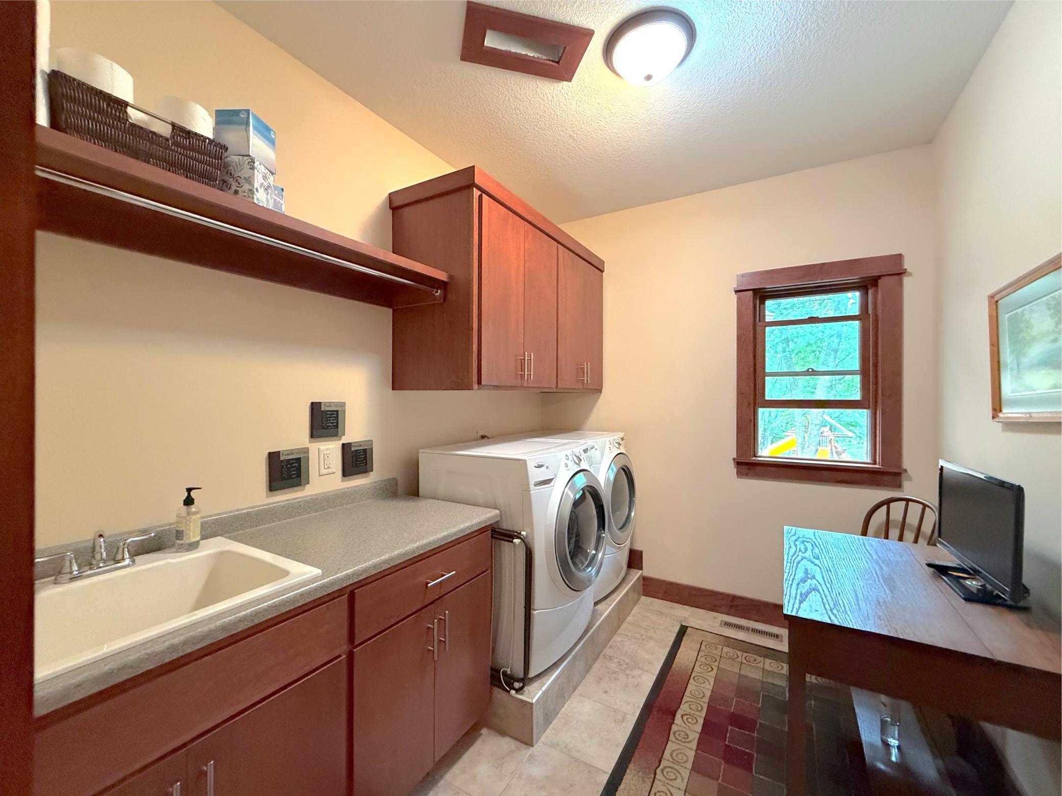 Combining function and convenience, this well-appointed laundry room offers extensive storage, a dedicated folding area, and room for additional organization.