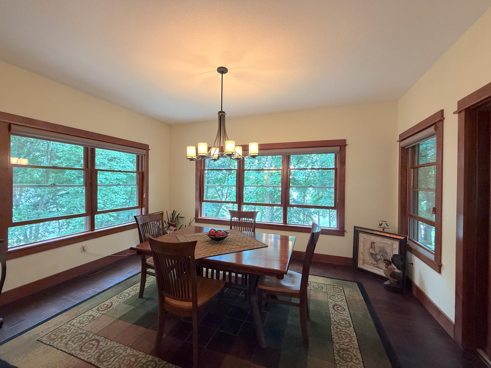 Surrounded by windows on three sides, this dining area offers a bright and inviting setting with peaceful views in every direction.