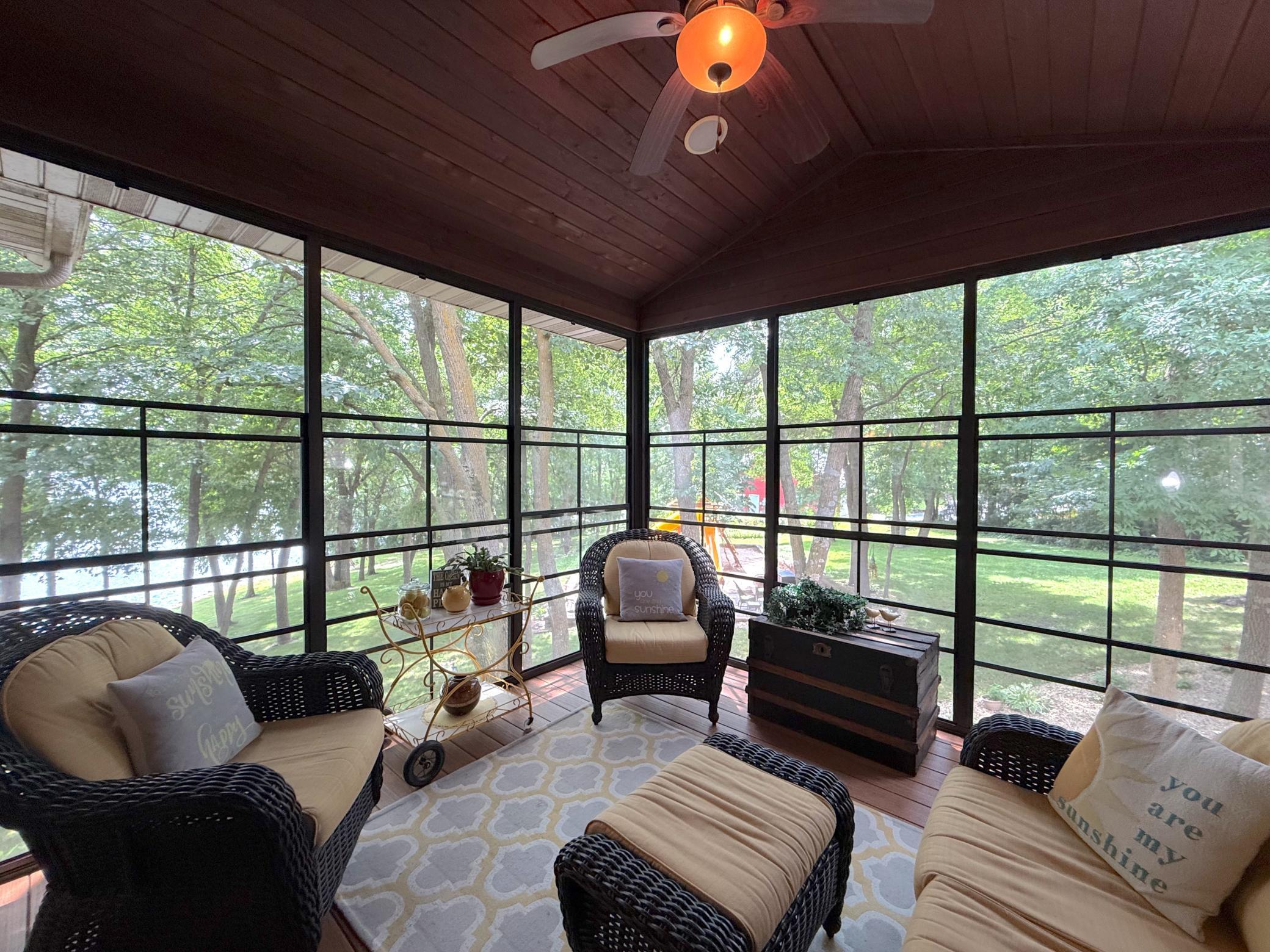 Unwind in the screened porch, where vaulted wood ceilings and serene lake views create the perfect retreat in every season.