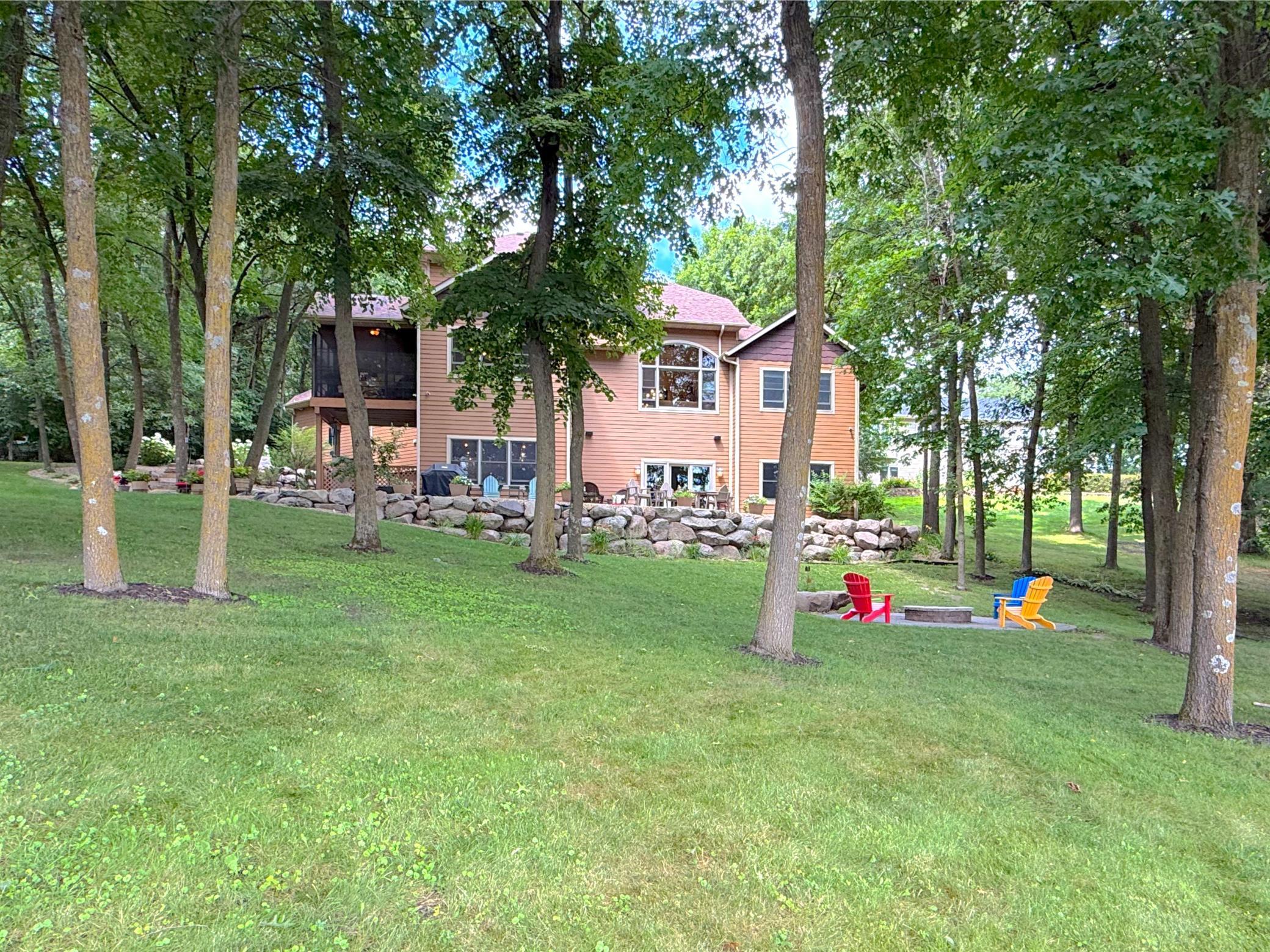The backyard retreat features a spacious patio, custom stone retaining walls, and multiple outdoor living areas perfect for entertaining family and friends.