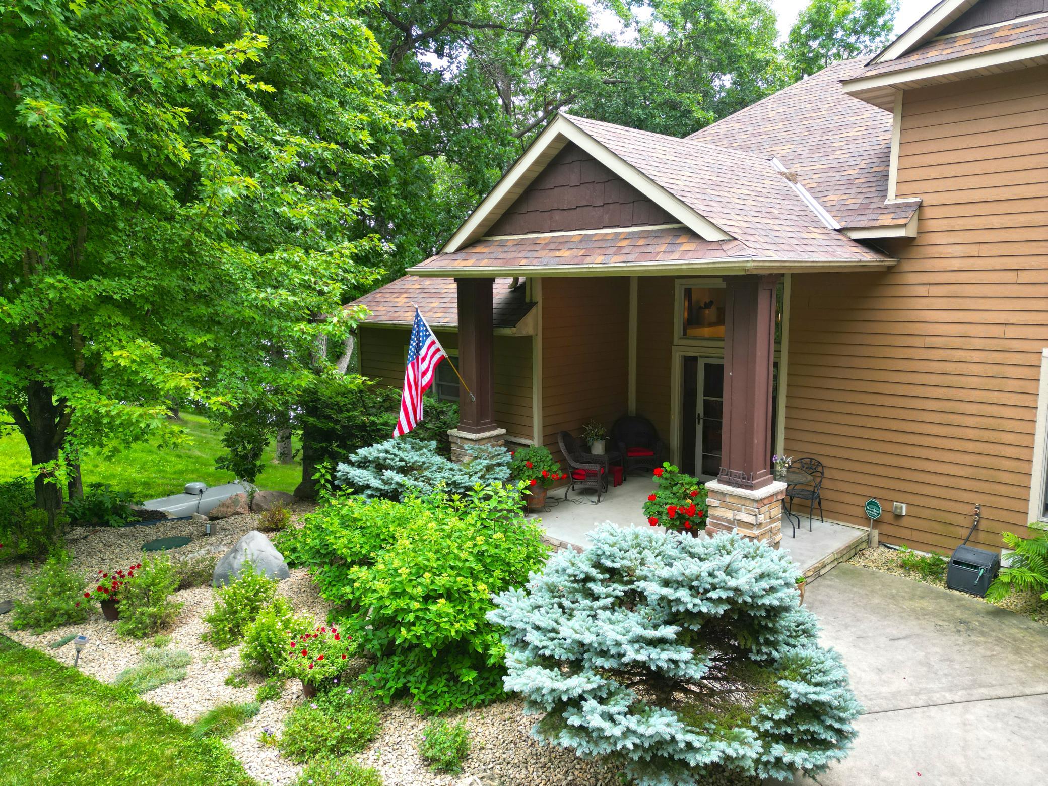 The spacious front porch provides a charming and inviting space to relax while enjoying the beautifully landscaped surroundings.