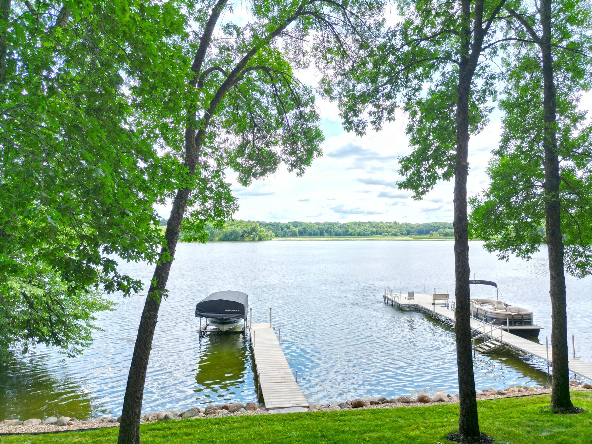 Enjoy panoramic Lake Louisa views from the beautifully maintained shoreline, where mature trees frame the scenery and a private dock invites endless days on the water.
