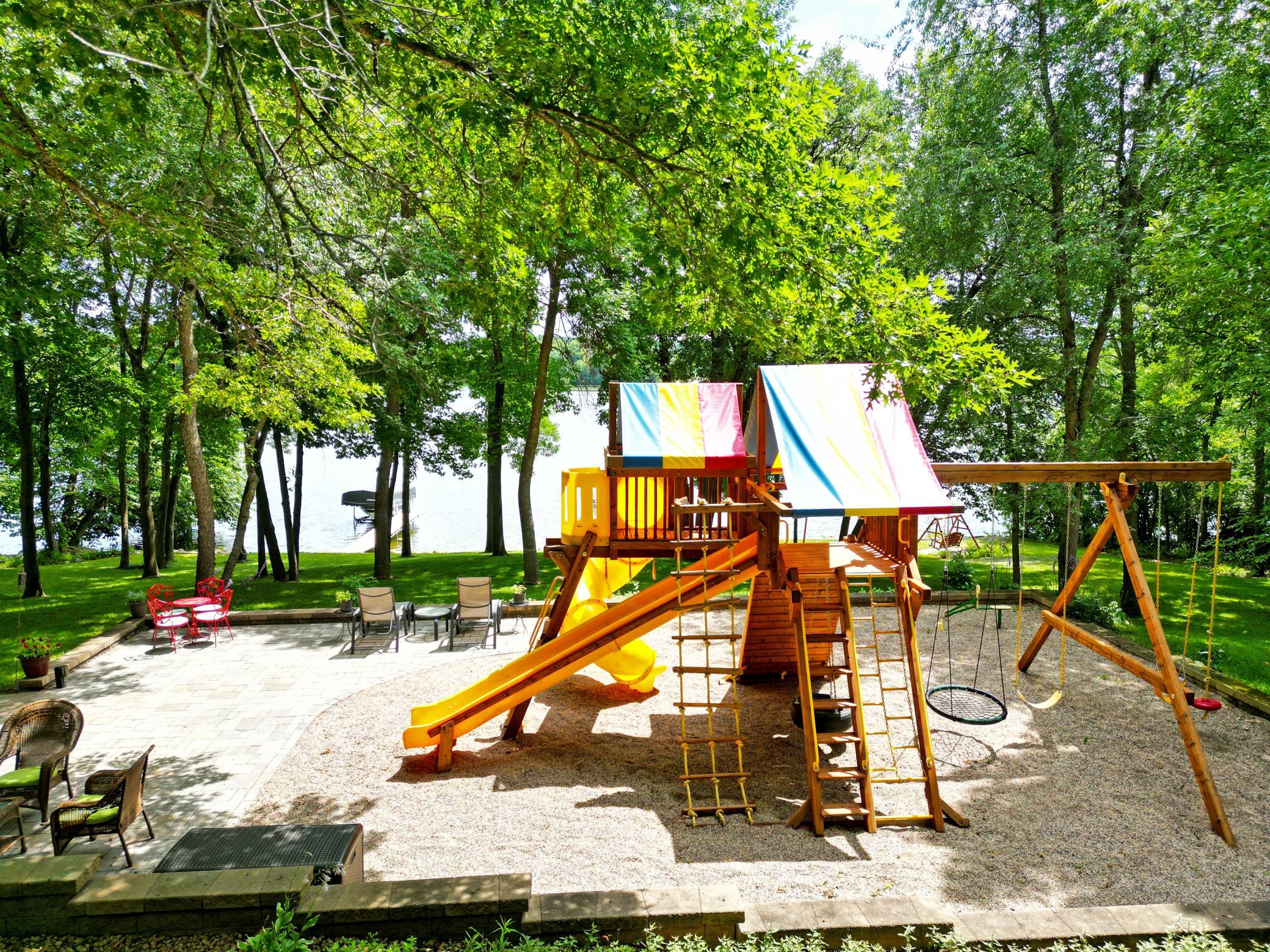 The expansive lakeside patio is designed for making memories, featuring multiple gathering spaces, and a Rainbow® playset for endless outdoor fun.