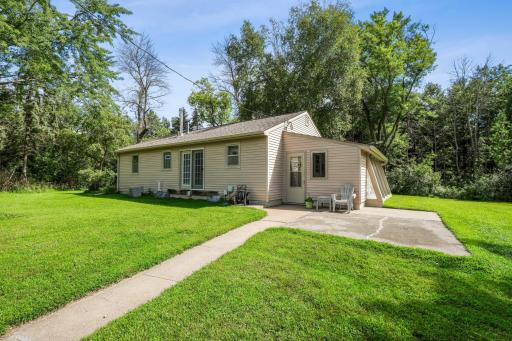 Inviting entrance with concrete patio, perfect for outdoor seating and enjoying the peaceful setting.