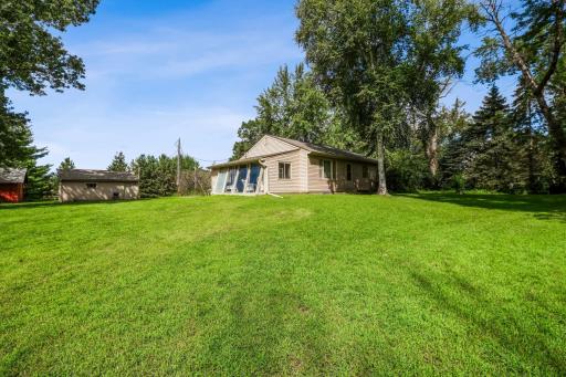 Expansive backyard with open green space and mature trees, offering privacy and plenty of room for outdoor activities.