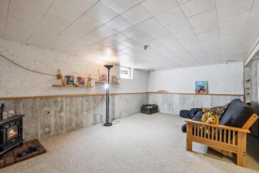 Finished basement space with built-in shelving, faux fireplace, and plenty of room for entertainment or a home theater.