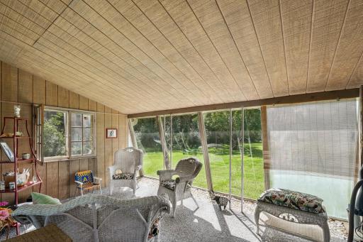 Bright and airy sunroom with floor-to-ceiling windows overlooking the lush backyard, perfect for morning coffee or afternoon relaxation.