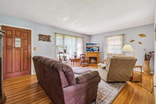 Bright and spacious living space with hardwood floors, natural light from multiple windows, and plenty of room for seating.
