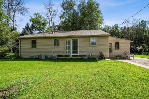 exterior view featuring vinyl siding, walkout doors, and a concrete patio area perfect for outdoor seating.